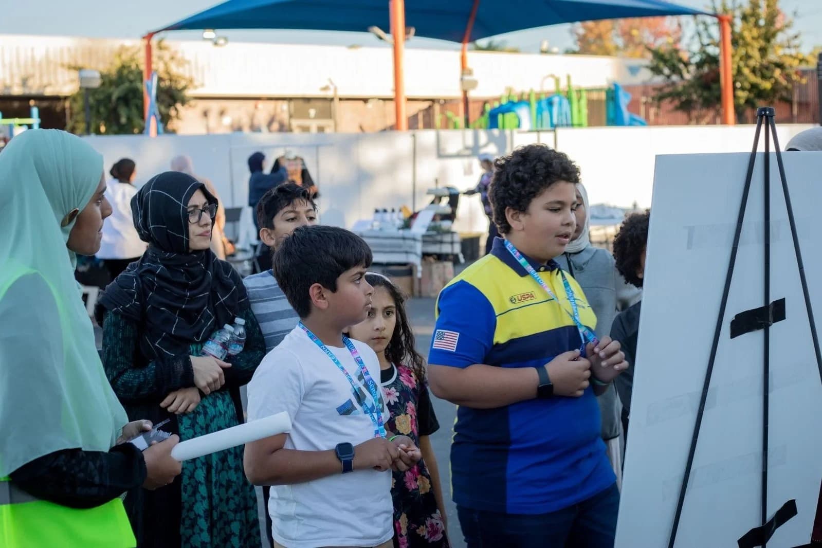 Children and parents gathered around an activity board at Bright Night 2025